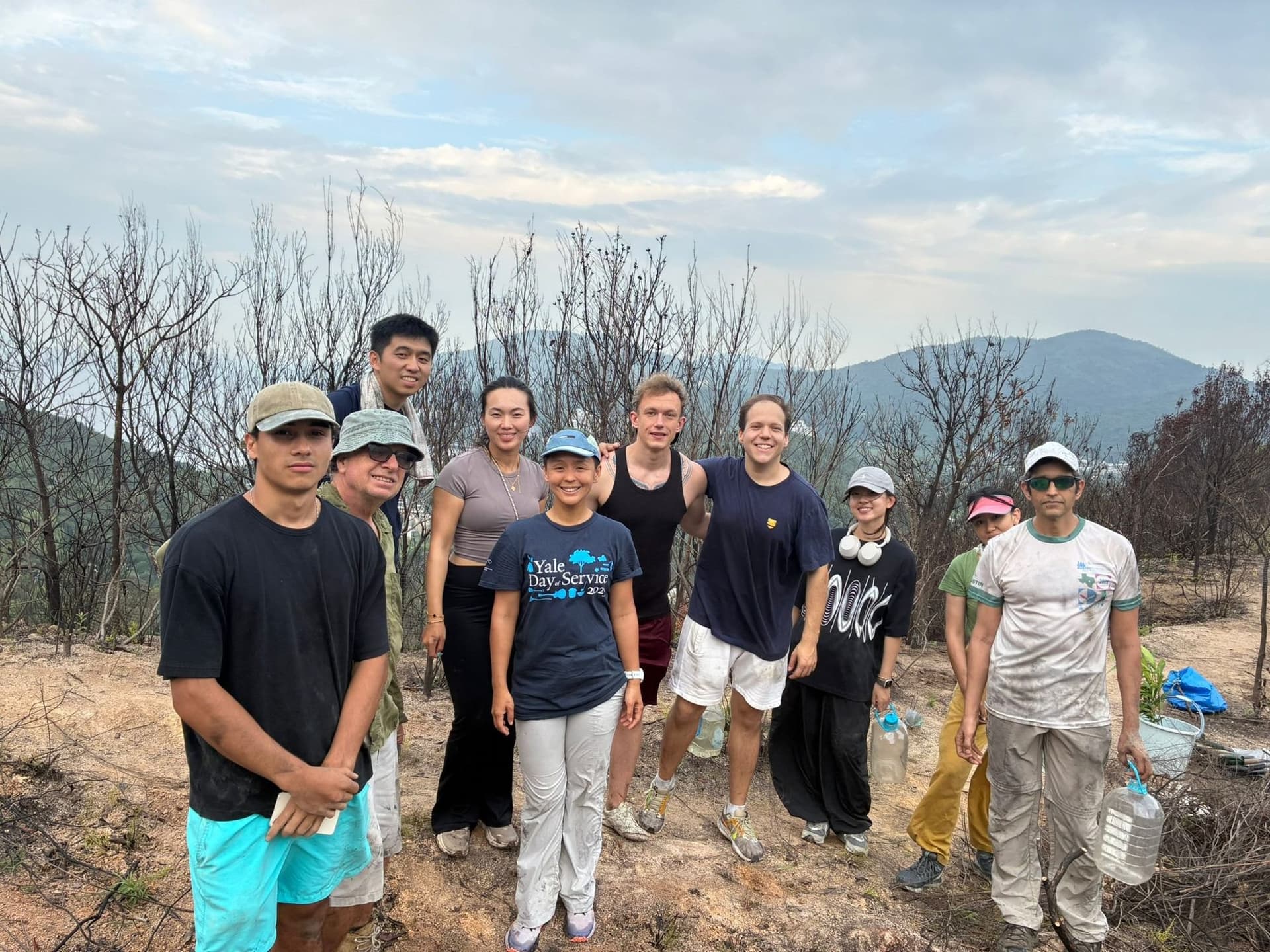 Volunteers standing on a replanted hillside on Lantau Island